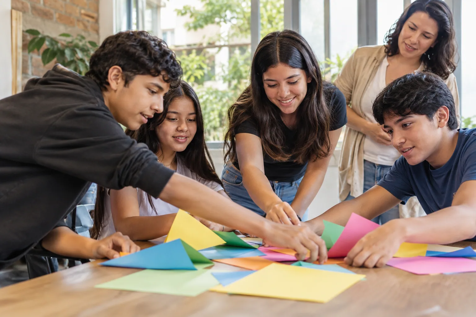 Adolescentes colaboran en una actividad grupal con una facilitadora.