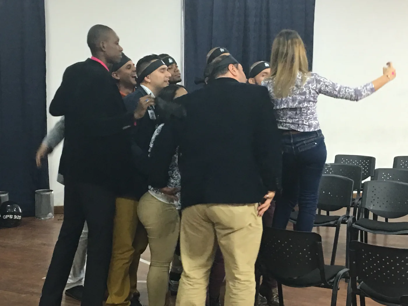 Grupo de personas adultas participando en una dinámica en una sala
